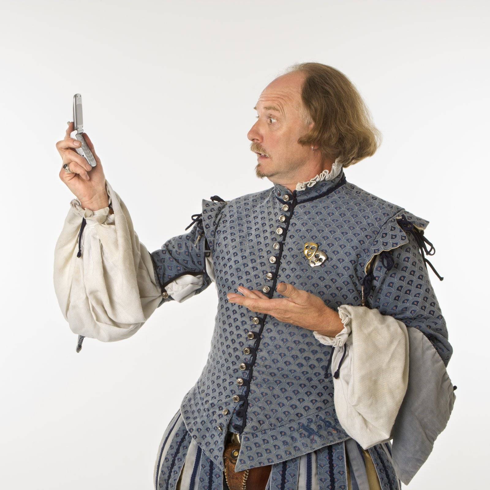 William Shakespeare in period clothing looking at cell phone with astonishment.