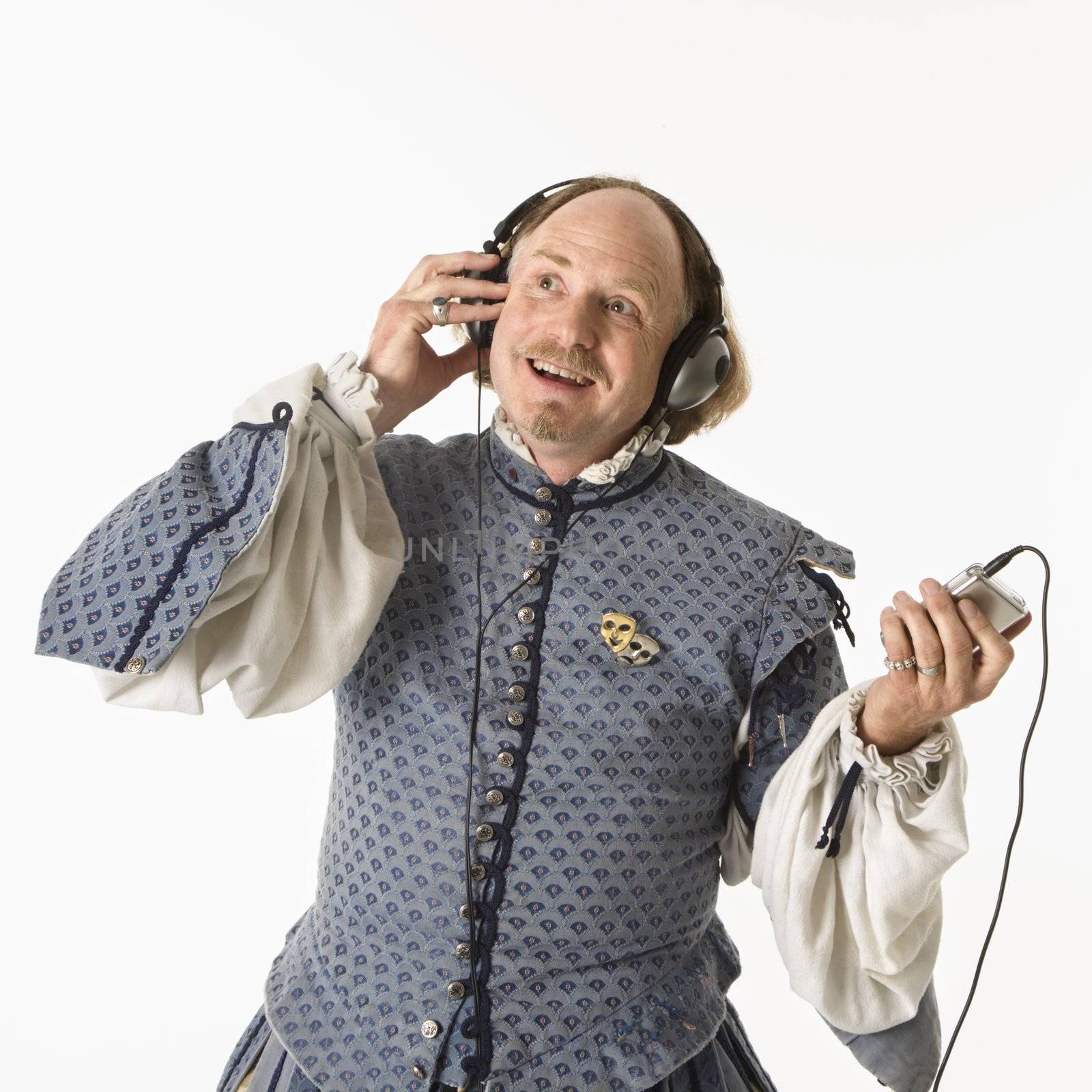 William Shakespeare in period clothing listening to mp3 player smiling.