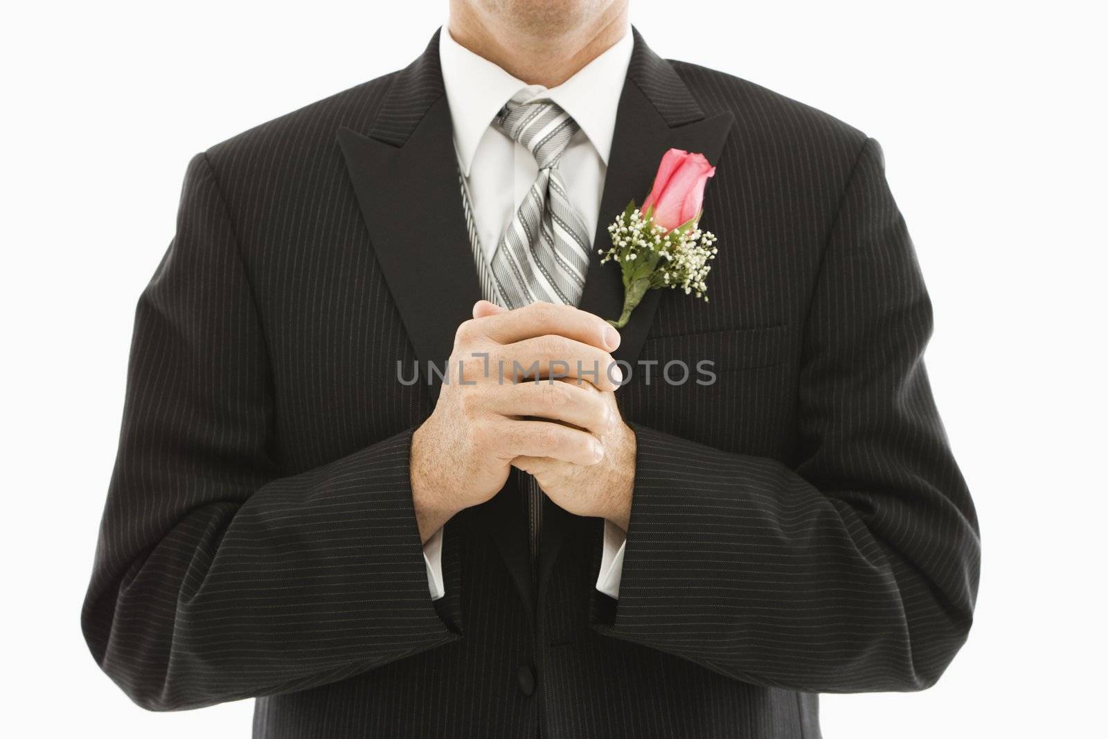 Close up of Caucasian groom with clenched fists.