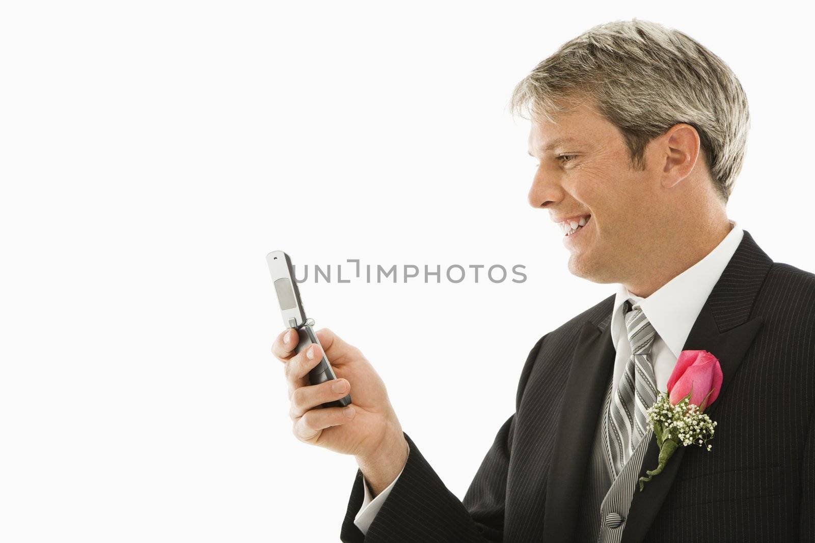 Caucasian groom using his cellphone.