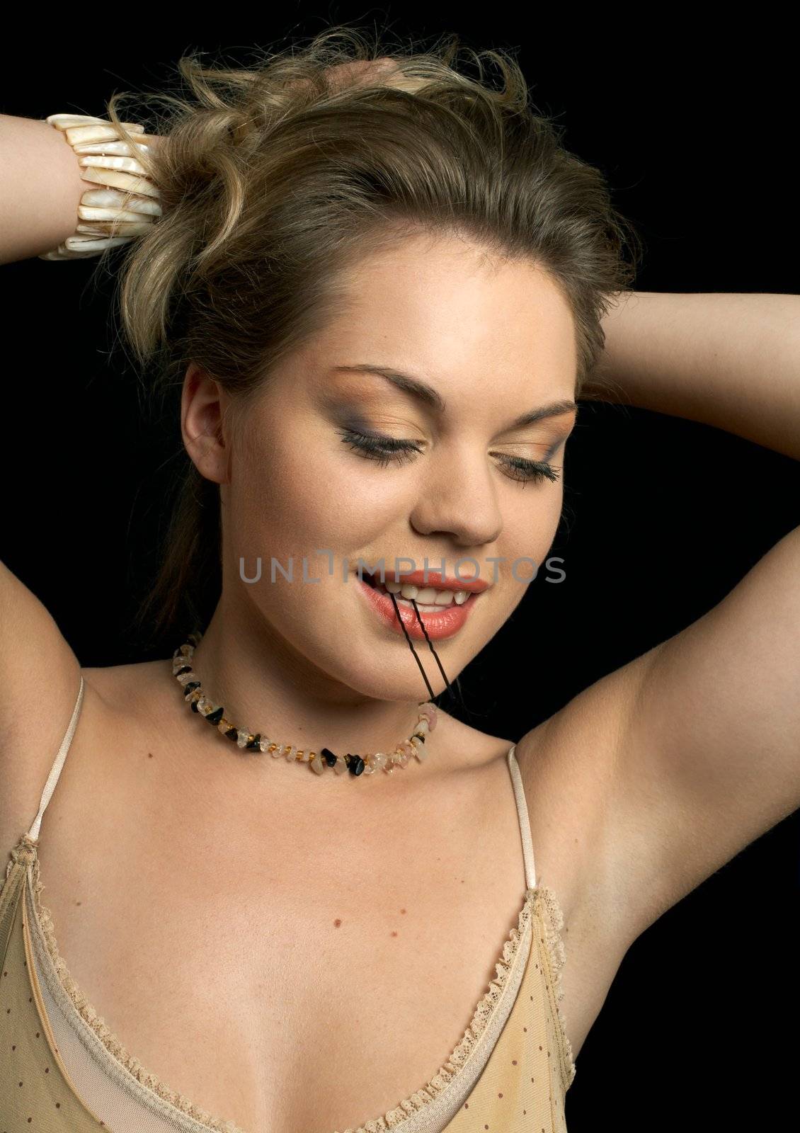 beautiful woman holding hair-pin in mouth