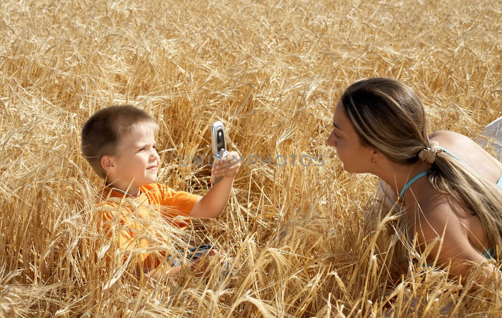 lovely kid picturing mom with cell phone