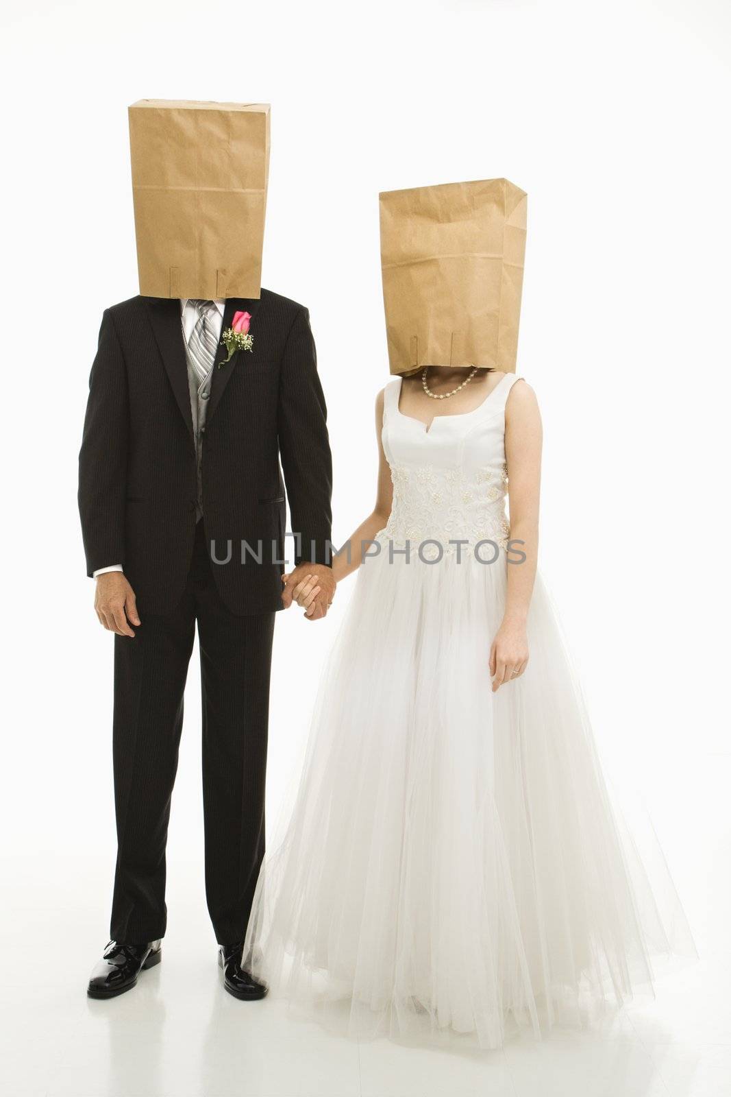 Caucasian groom and Asian bride with brown paper bags over their heads.