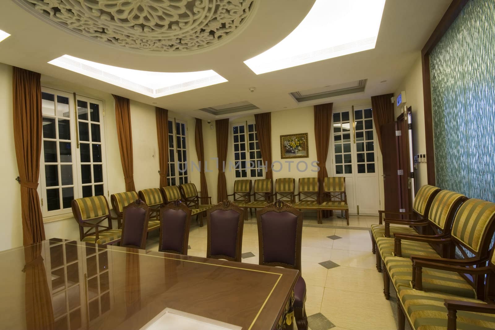 A large mahogany conference room table with leather chars
