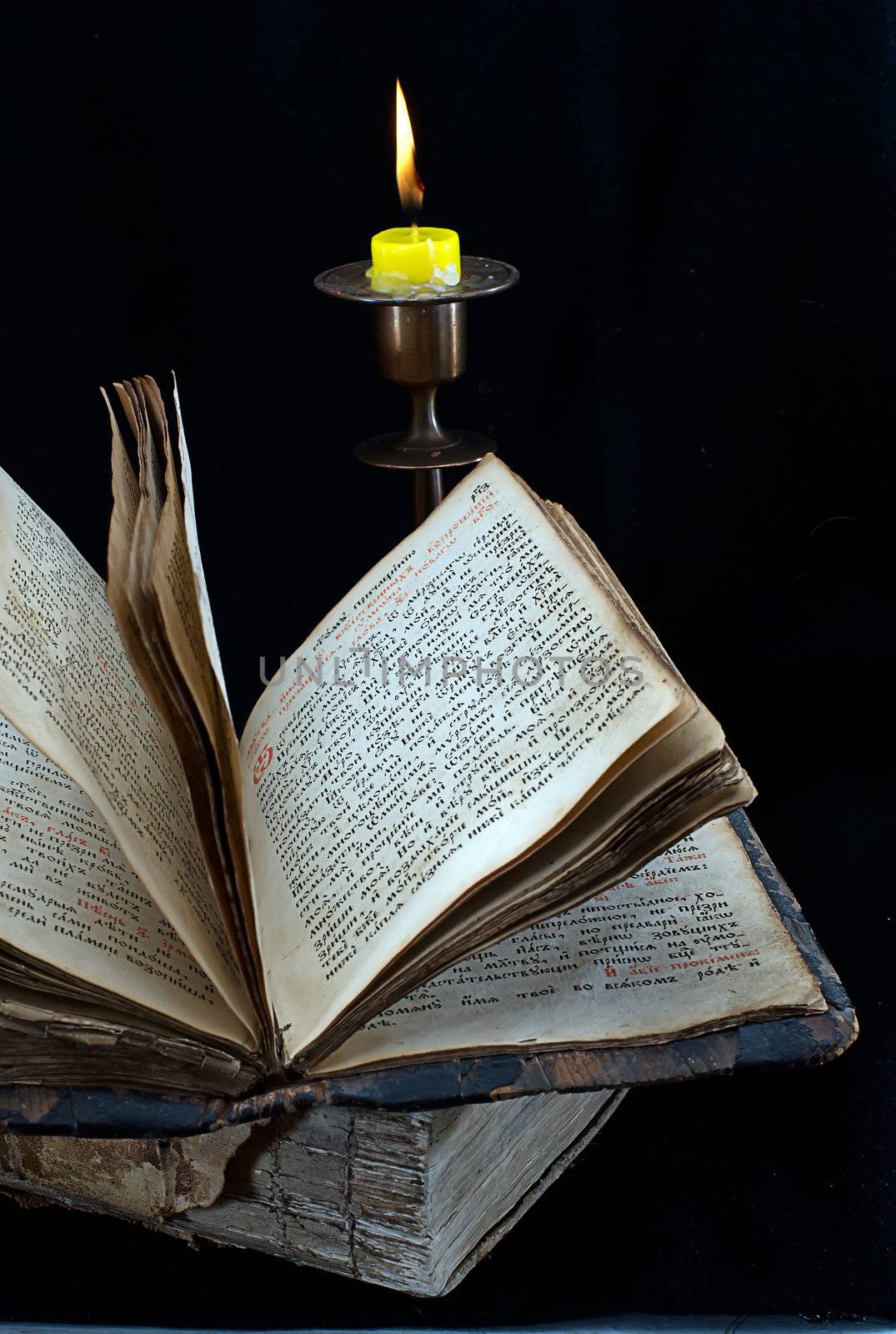 old religious book and candlestick with candle