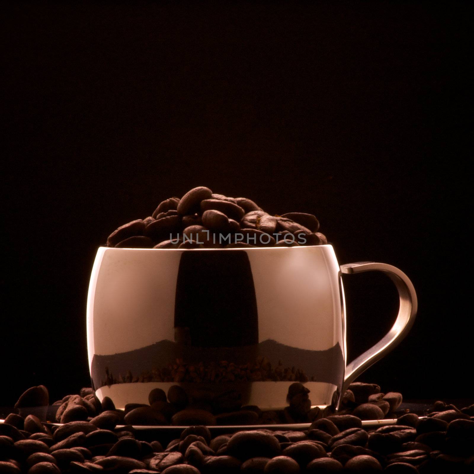 Bronze colored cappuccino cup with whole beans lit to resemble a theater with audience.