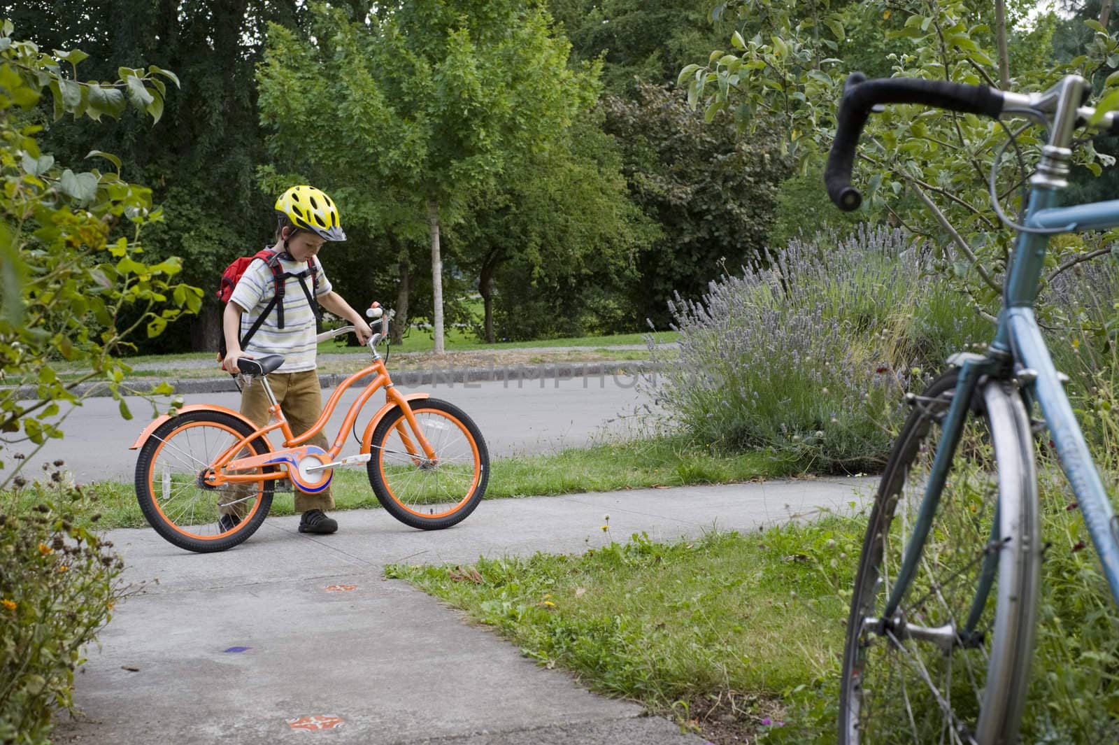 young boy ready for bike ride with adult bike foregound by rongreer