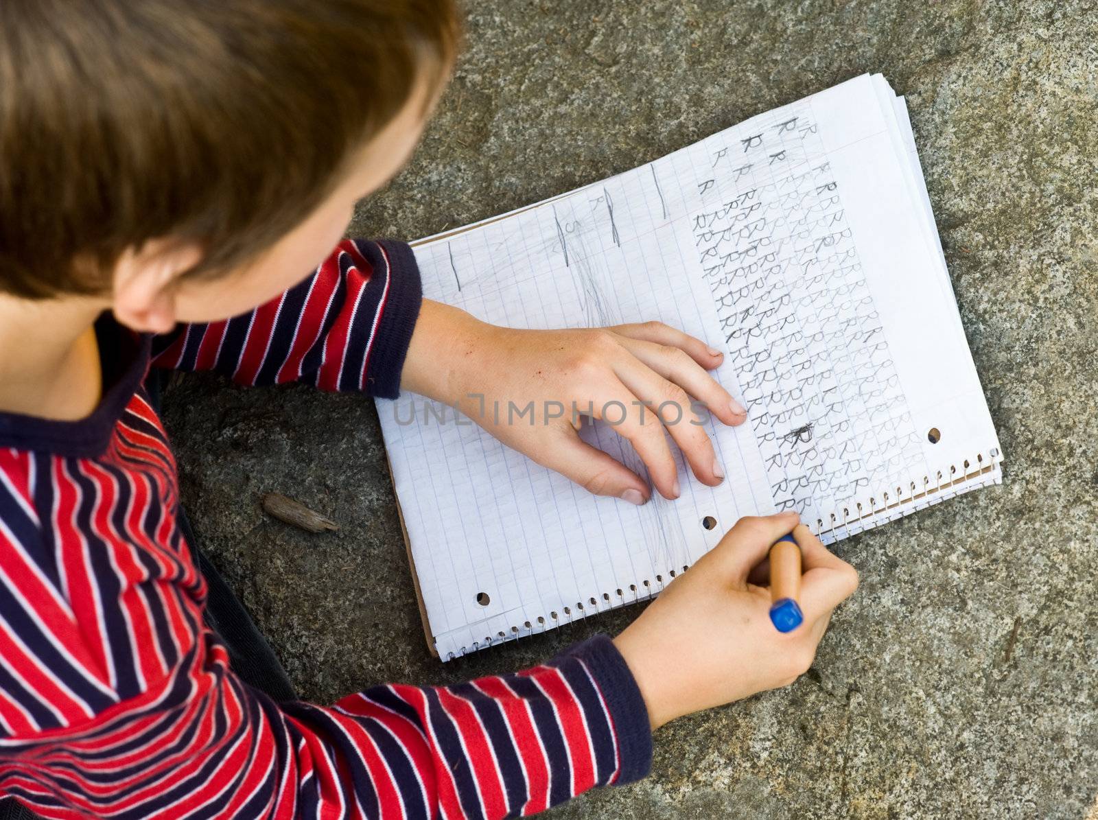 boy doing writing homework by rongreer