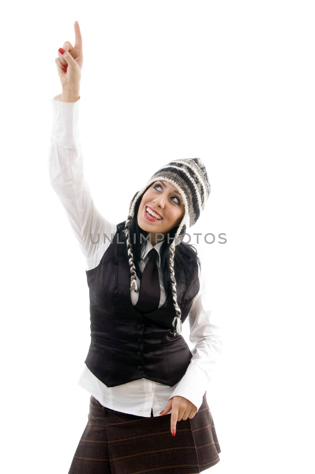 attractive young female wearing cap pointing upwards on an isolated white background