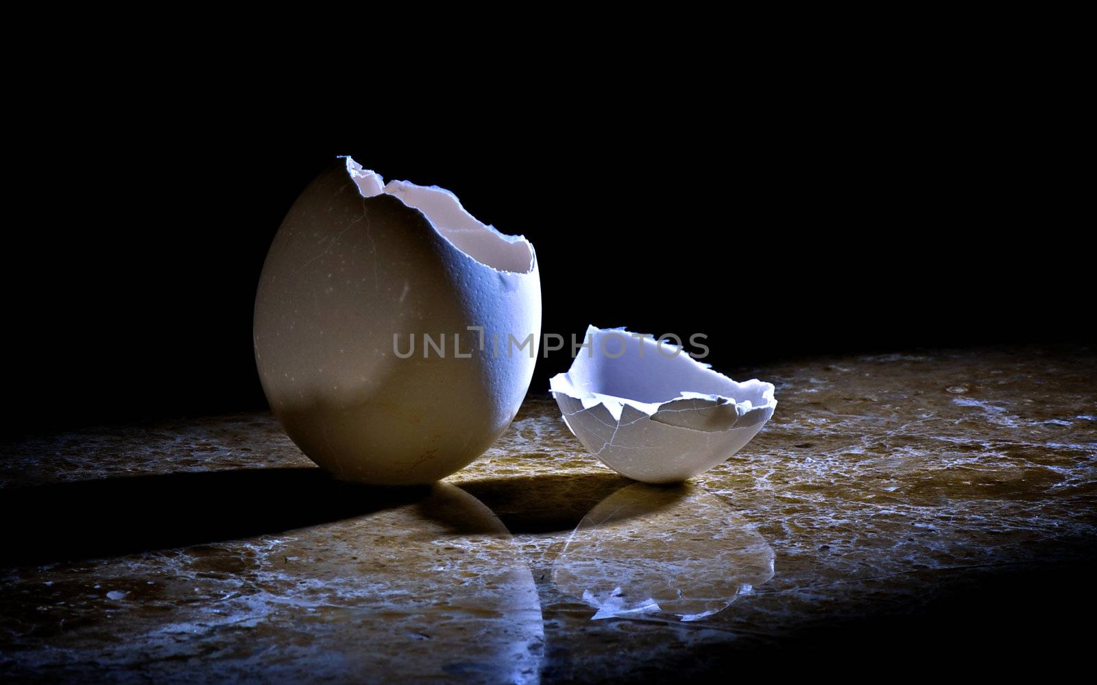 Concept photo suggesting an escape.

Hatched egg lit by a spotlight on a marble base in a darkened room