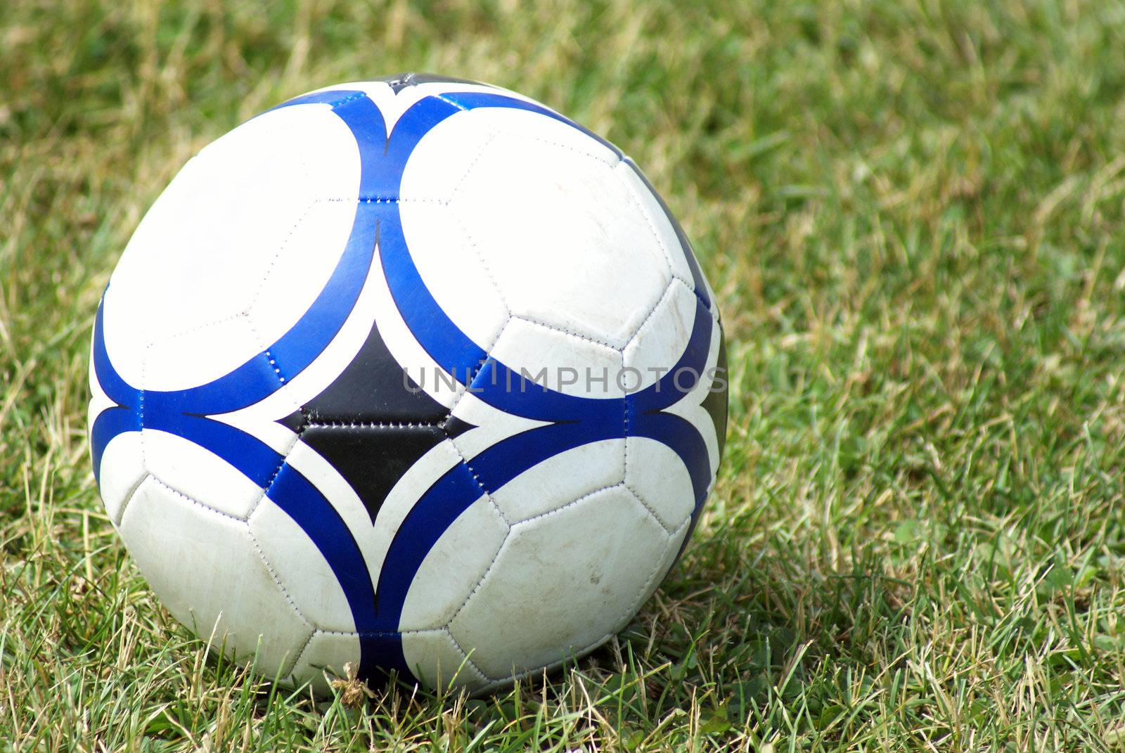 A soccer ball sits on the field of grass.