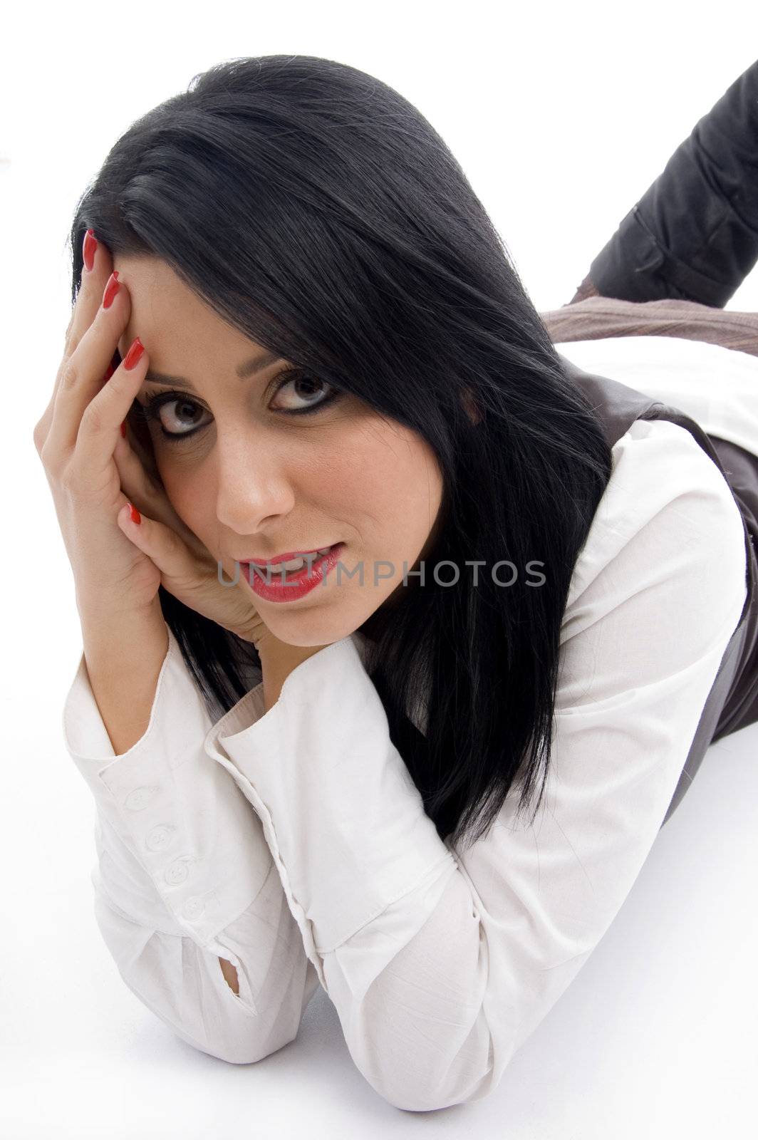 caucasian model lying down on floor and looking at camera against white background