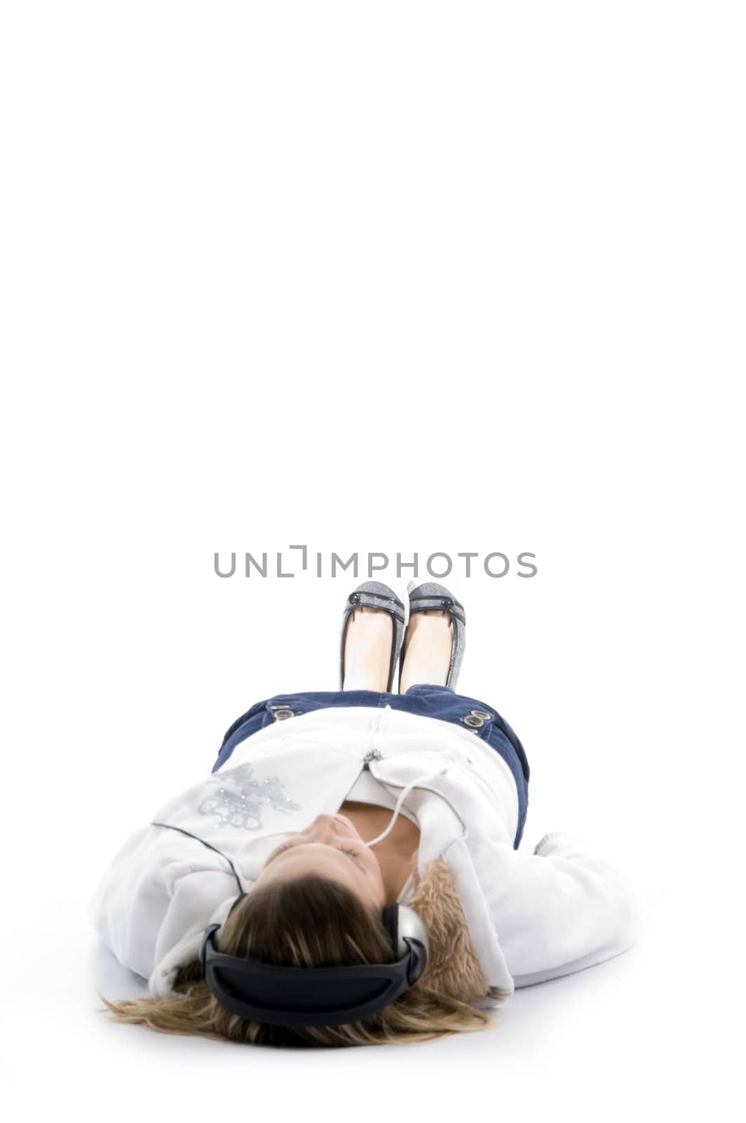 young model lying straight and wearing headphones against white background