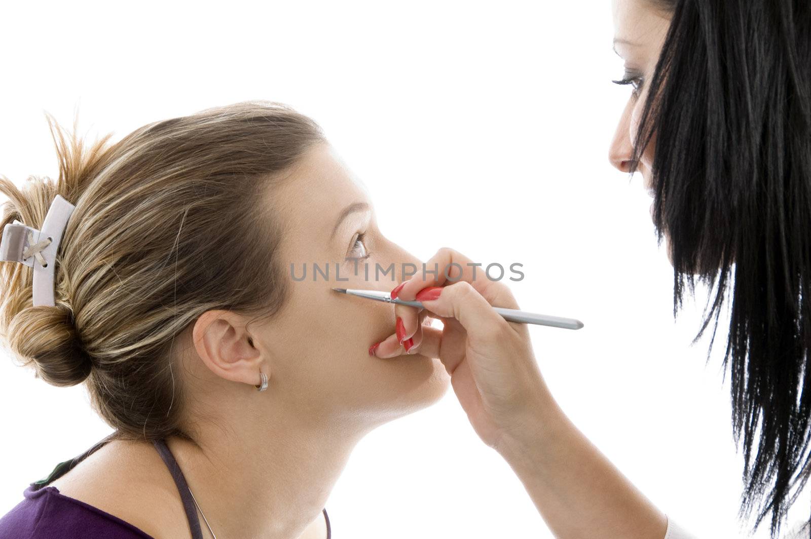 model getting eye makeup from beautician by imagerymajestic