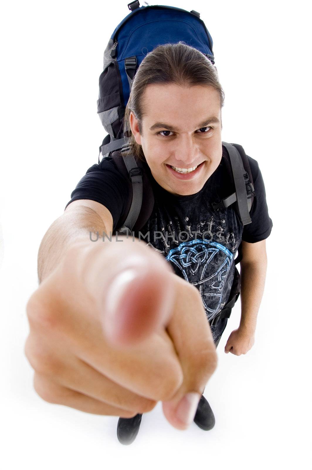 young traveler with bag pack pointing at camera against white background