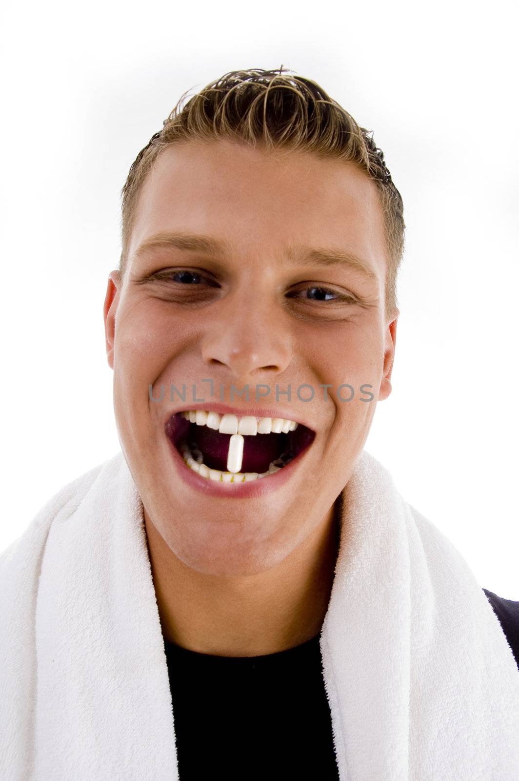 man holding white capsule between his teeth on an isolated white background