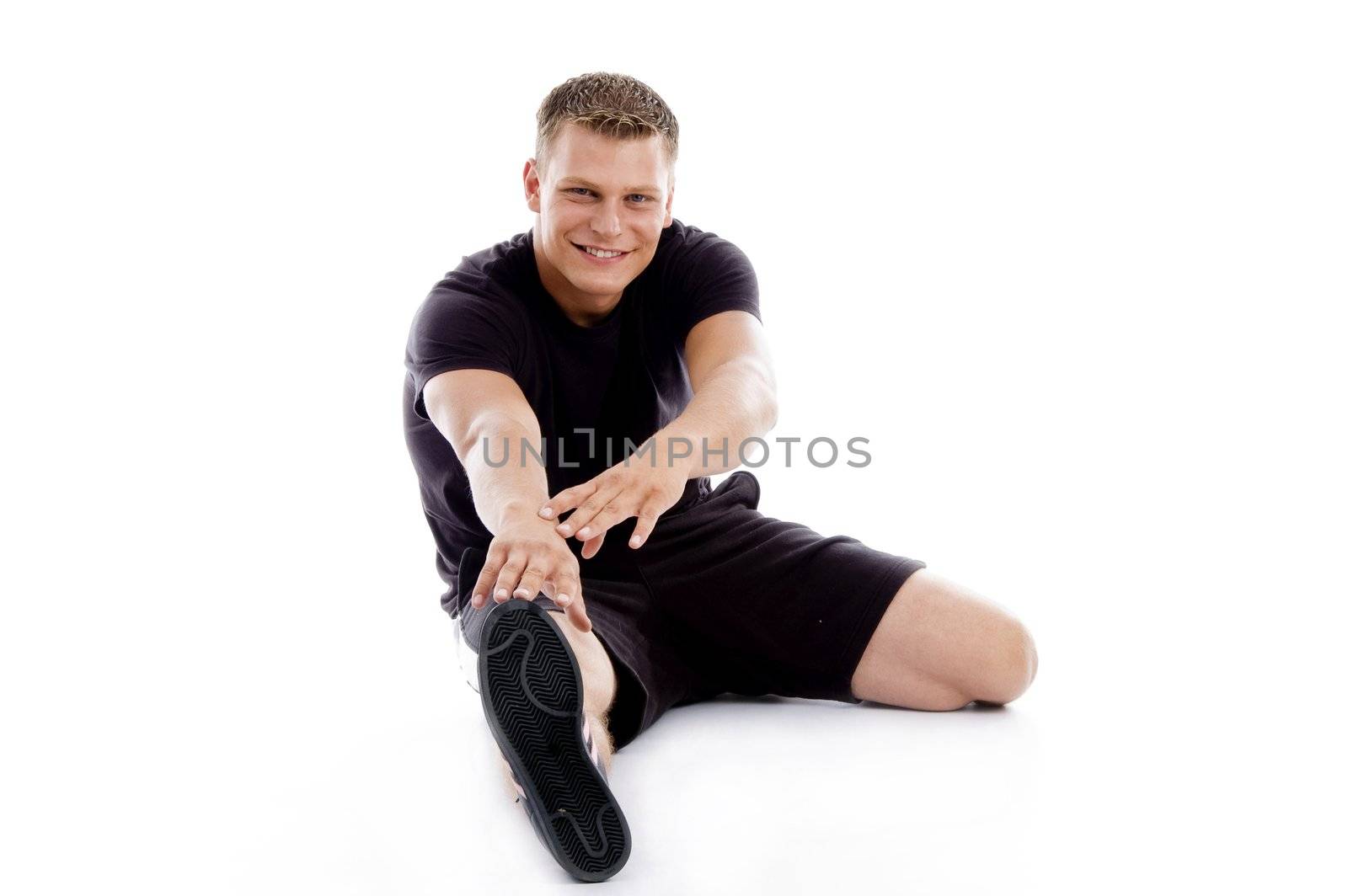 muscular man stretching his legs and hands on an isolated white background