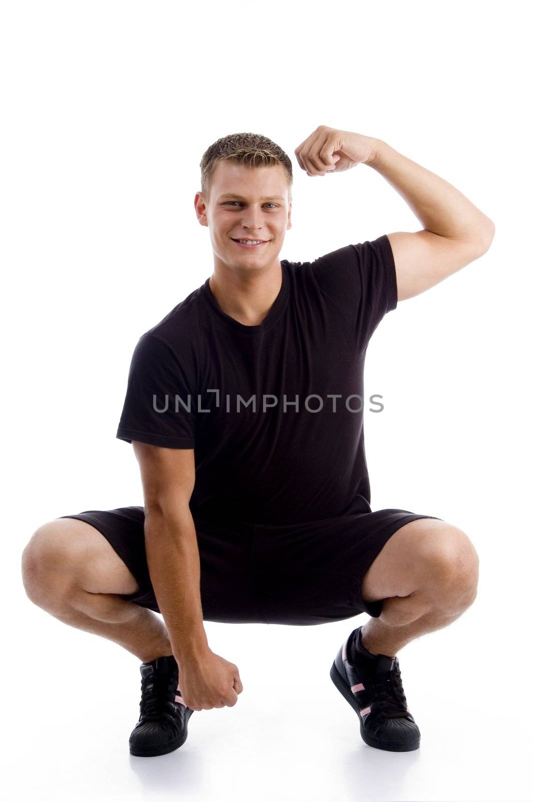 sitting muscular man showing his muscles against white background