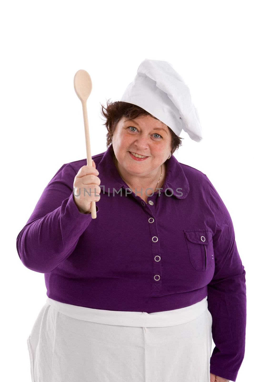 50 year old lady waving her wooden spoon wearing a chef's hat and apron