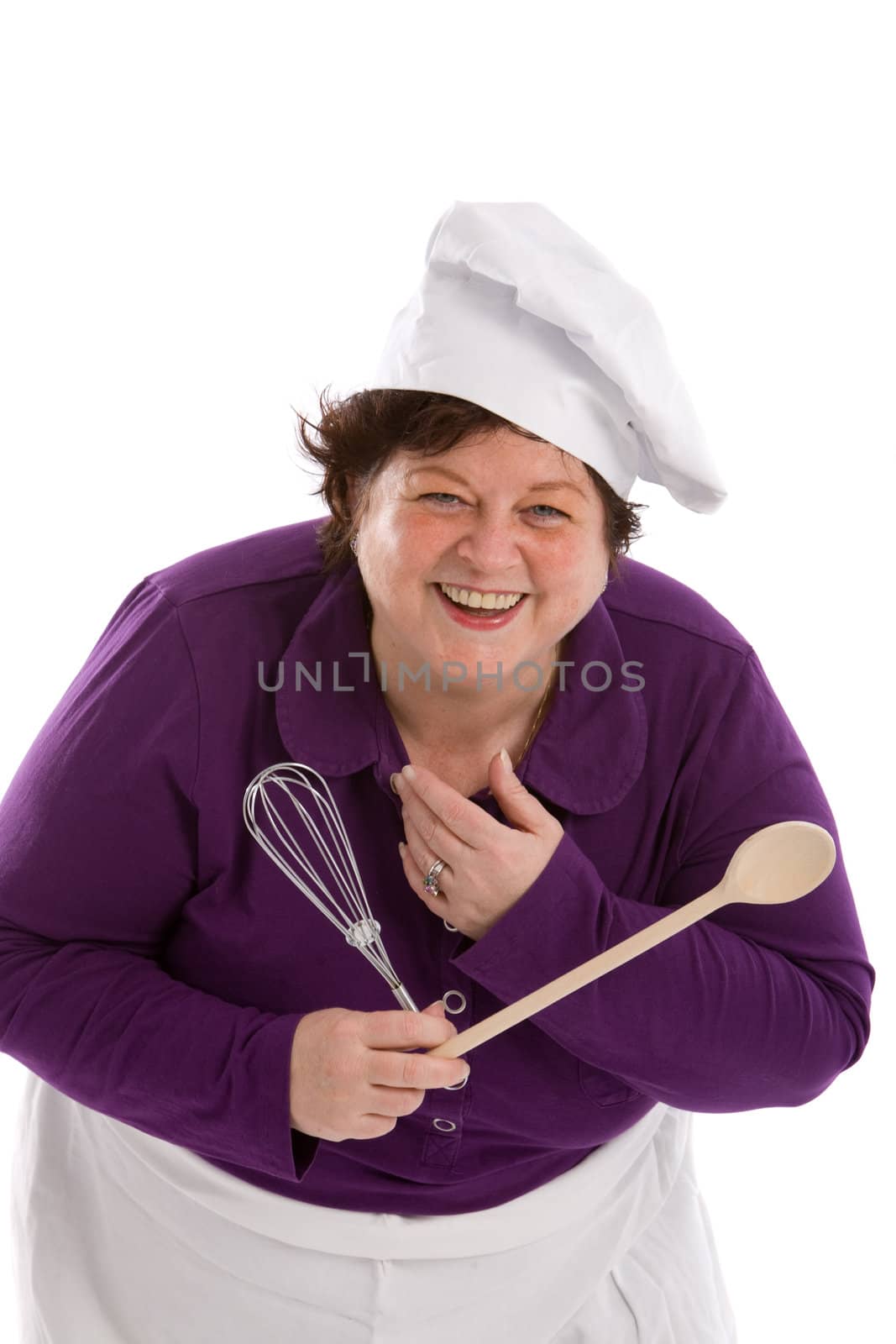 Woman holding a wooden spoon and a mixer and laughing on white