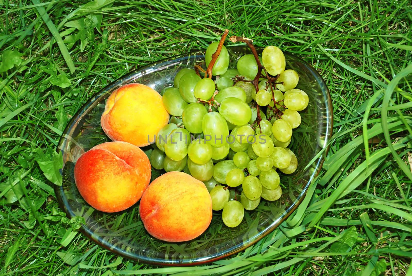 fresh rape peaches and grapes in green grass