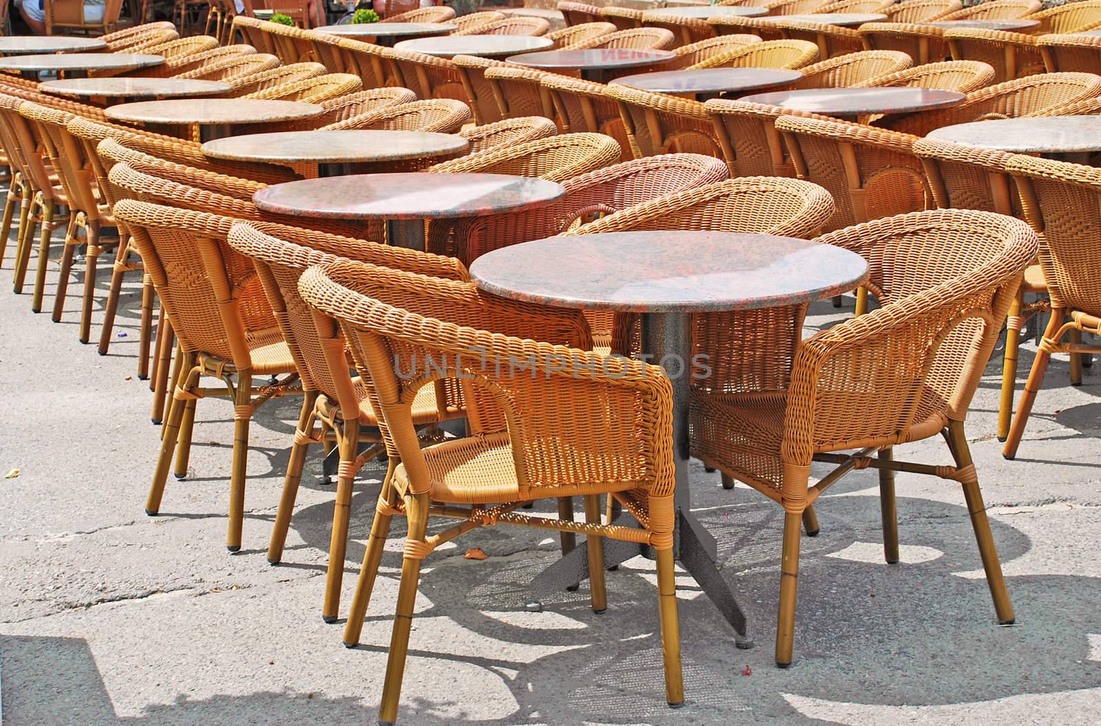 restaurant street terrace with wicker chairs and round tables