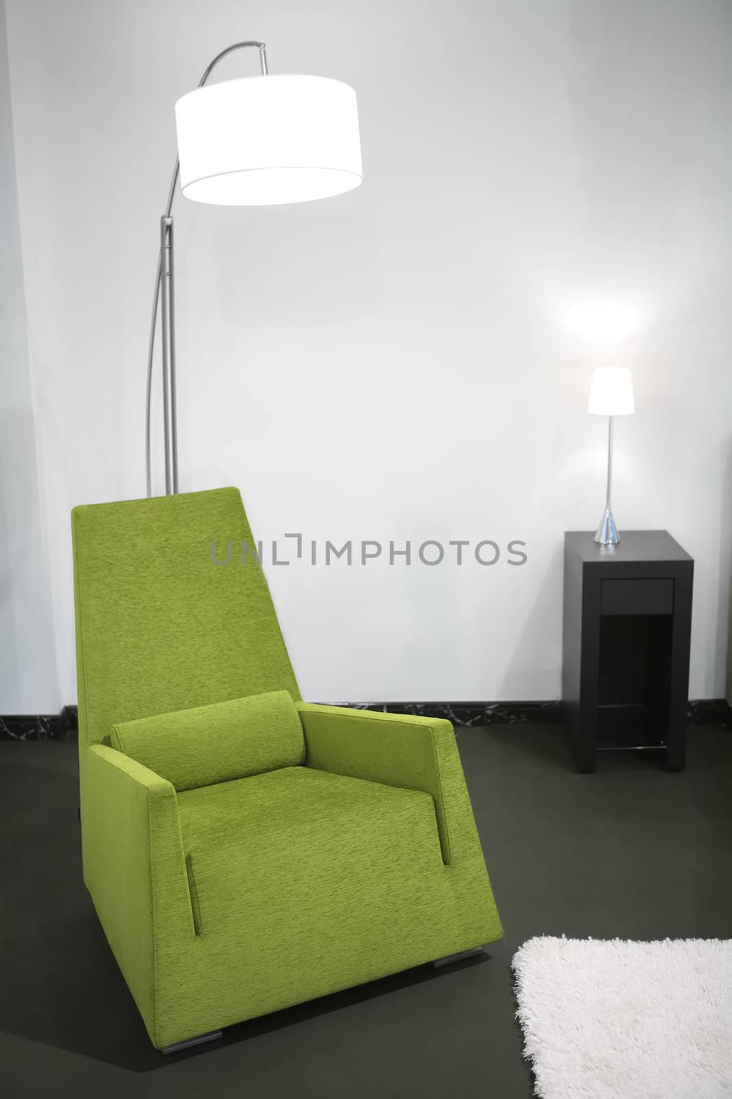 fragment of the interior with green easy-chair and floor-lamp 