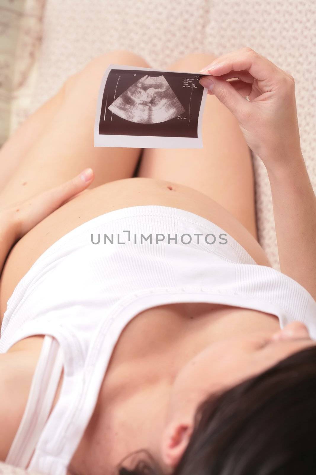 Expectant mother, admiring ultrasound  of her unborn baby