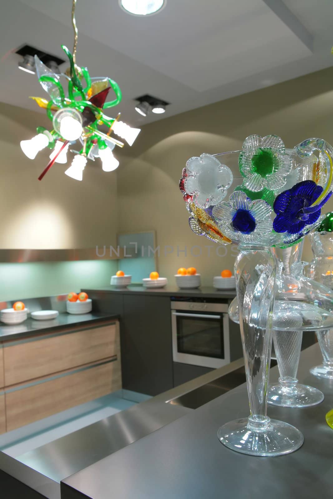 glass vase with graceful flowers in interior of the kitchens with oranges and beautiful chandelier