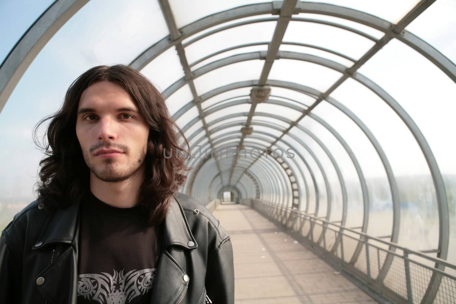 closeup portrait of the long-haired man in transparent concentric glass tunnel