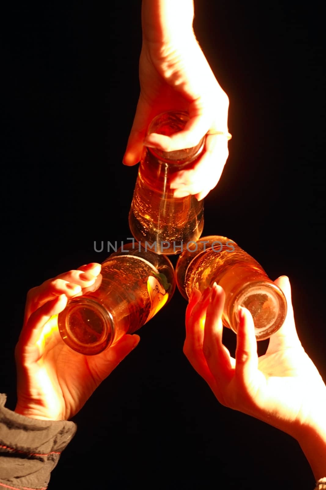 three glass with beer in women hands on black background