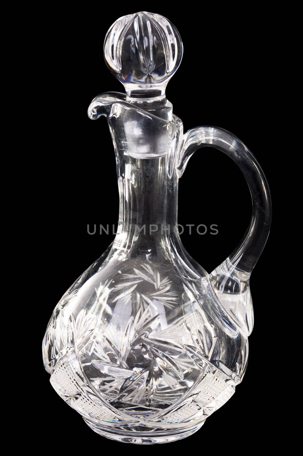 Glass empty carafe with stopper on the black background