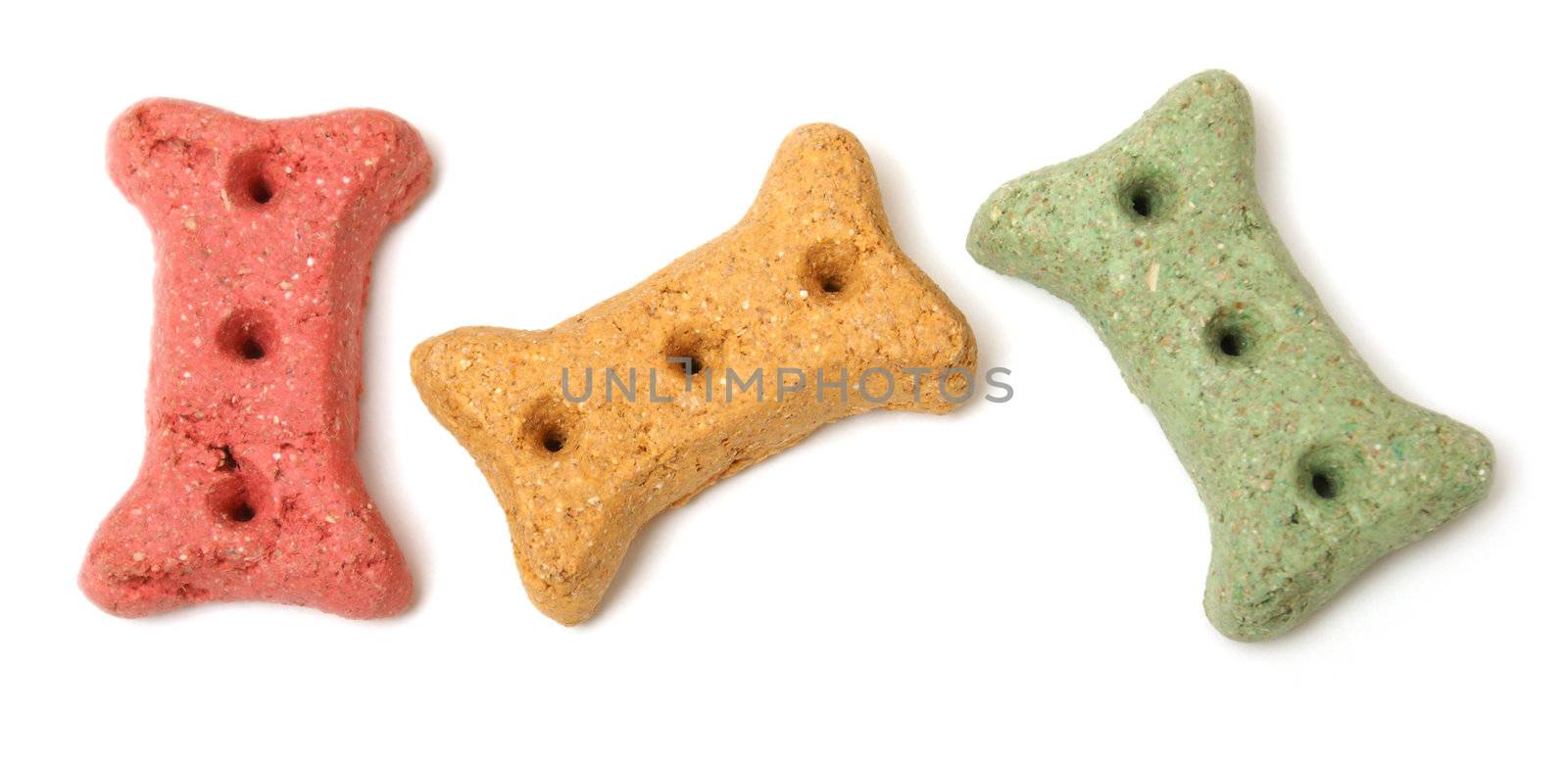 Three different coloured dog treats in the shape of a bone.
