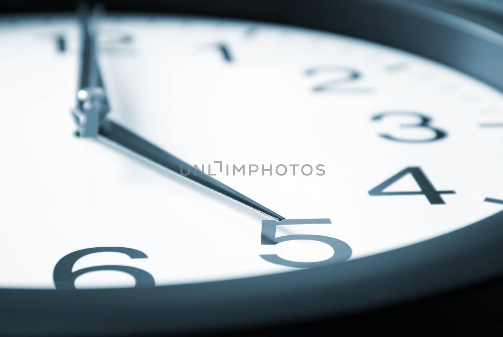 A macro shot of a clock striking five.