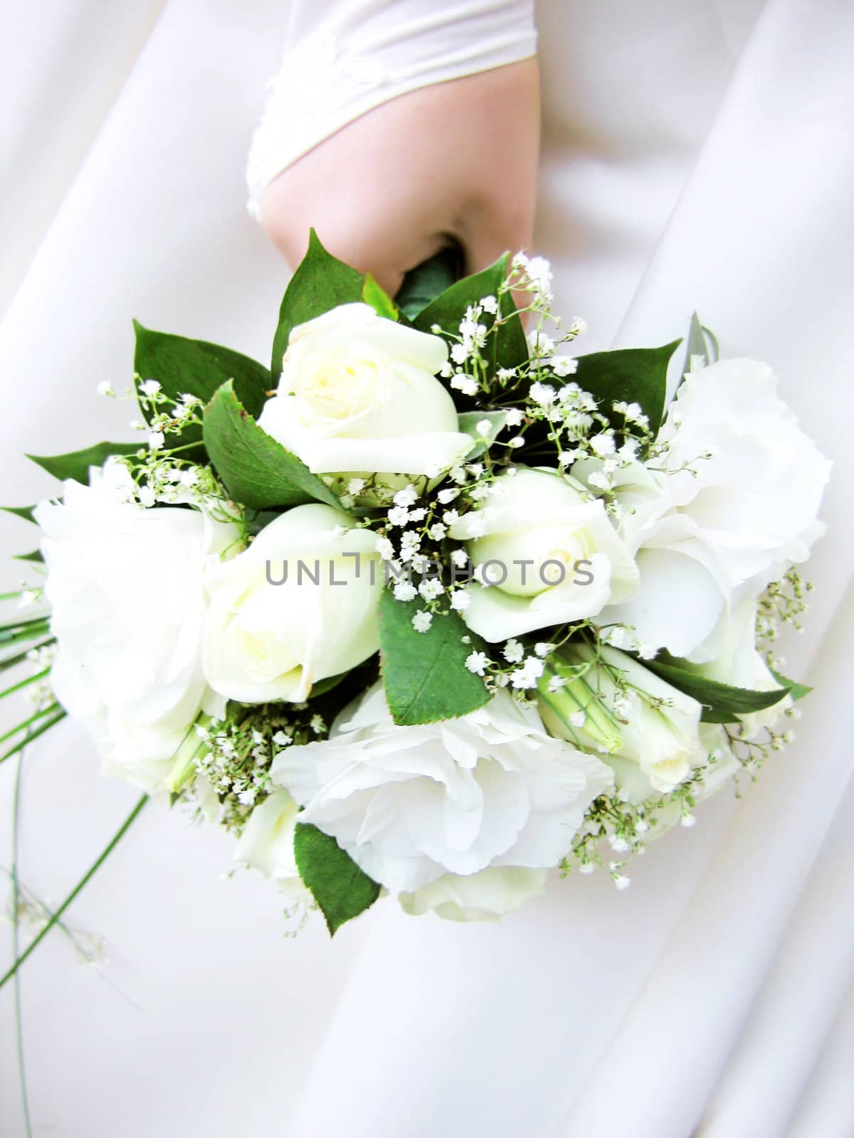 wedding bouquet of white roses in hand of the bride