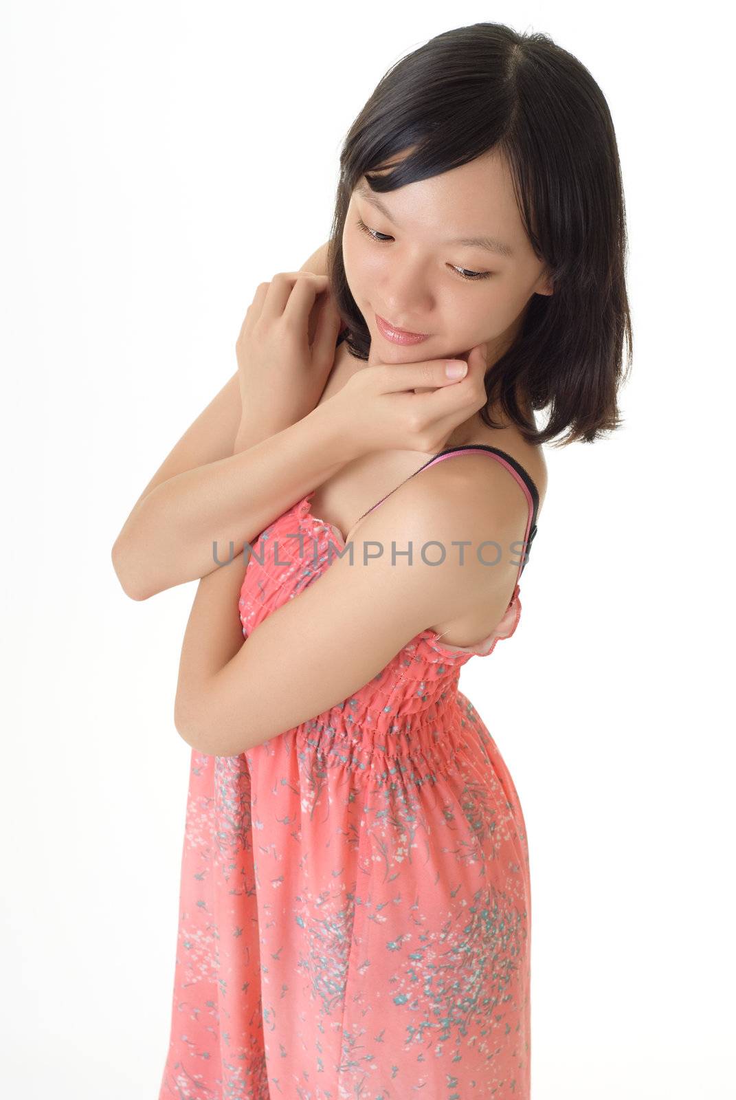 Oriental girl with pink dress standing against white background.
