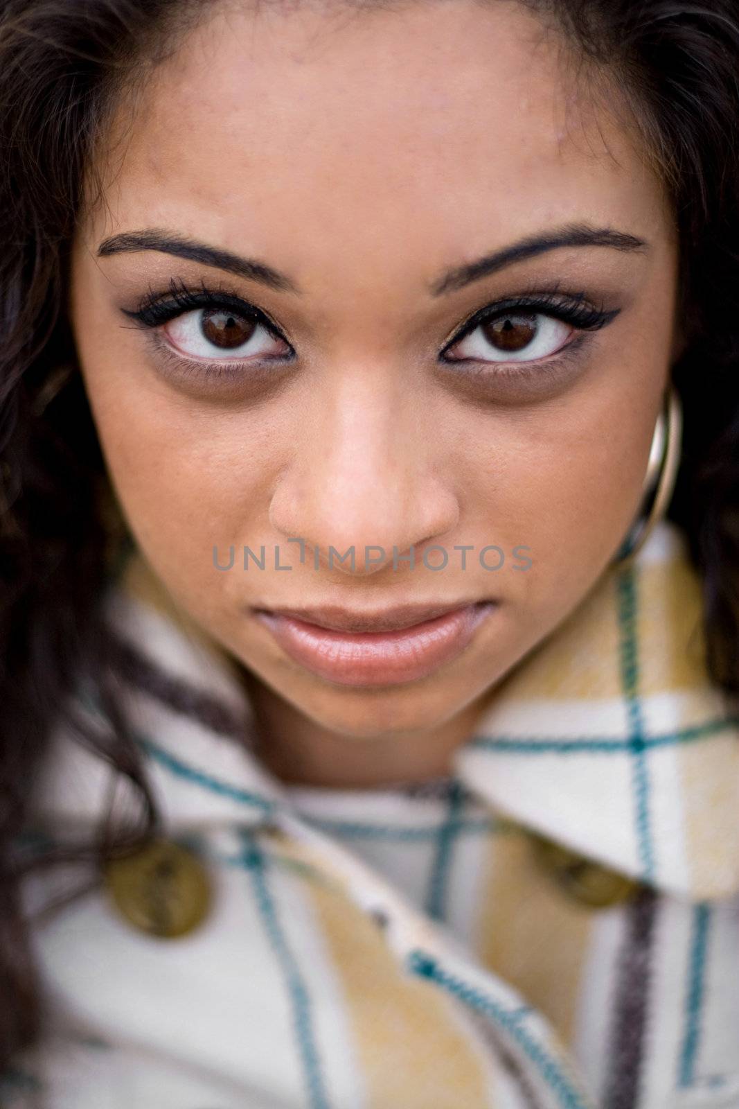 A closeup of a pretty Indian woman from a high angle.  Shallow depth of field with strong focus on the eyes.