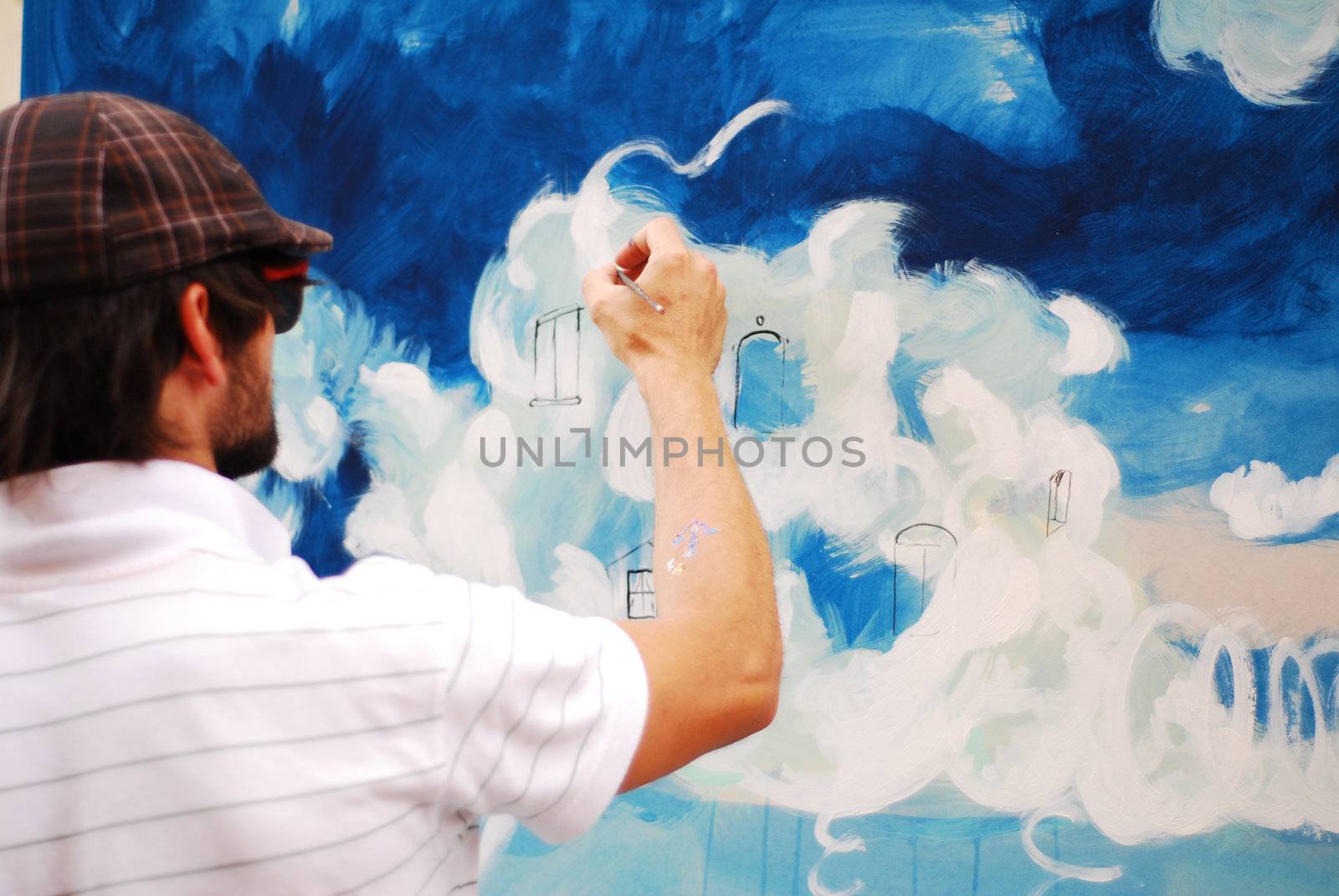 image with a young man painting taken from behind