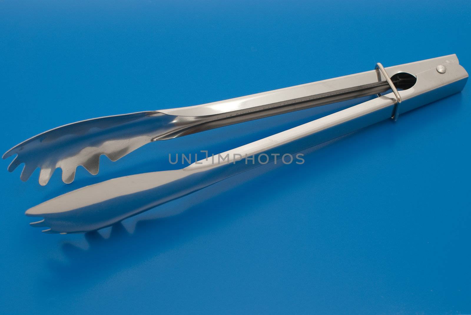 Barbecue plier isolated on the blue background.