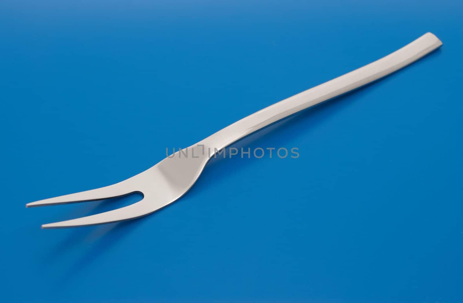 Barbecue carving fork isolated on the blue background.