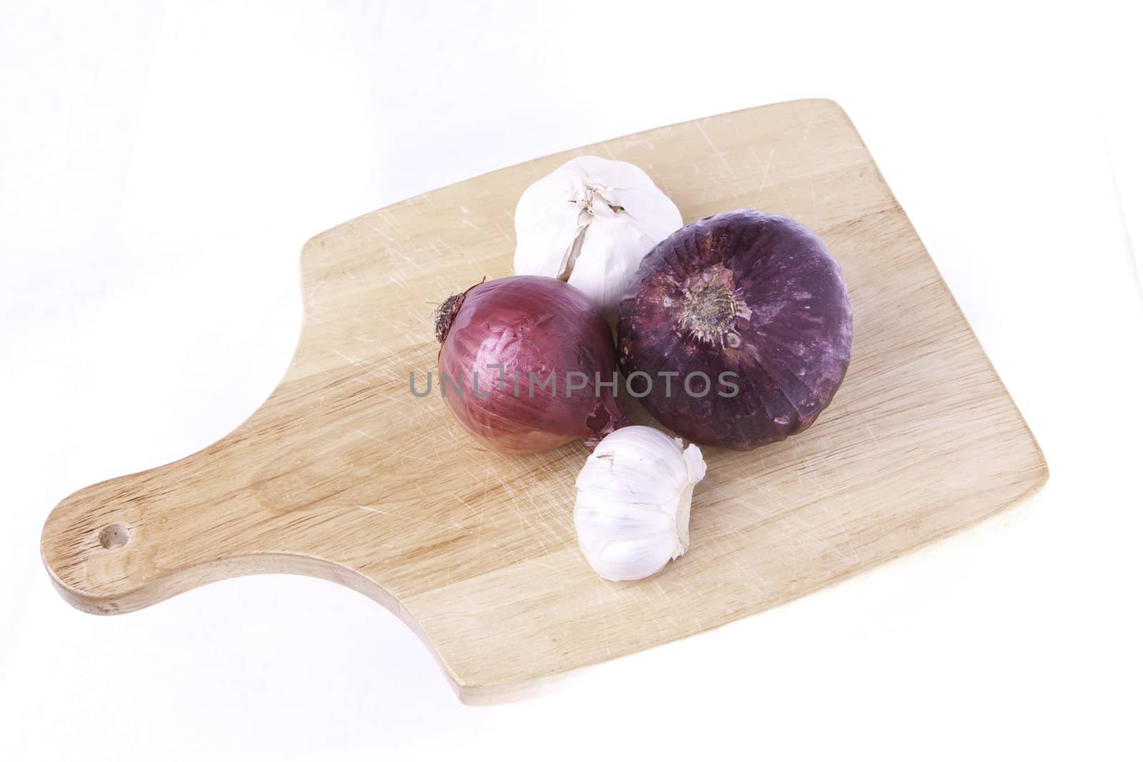 A selection of vegetables of root foods on a cutting board ready for cutting isolated on a white background