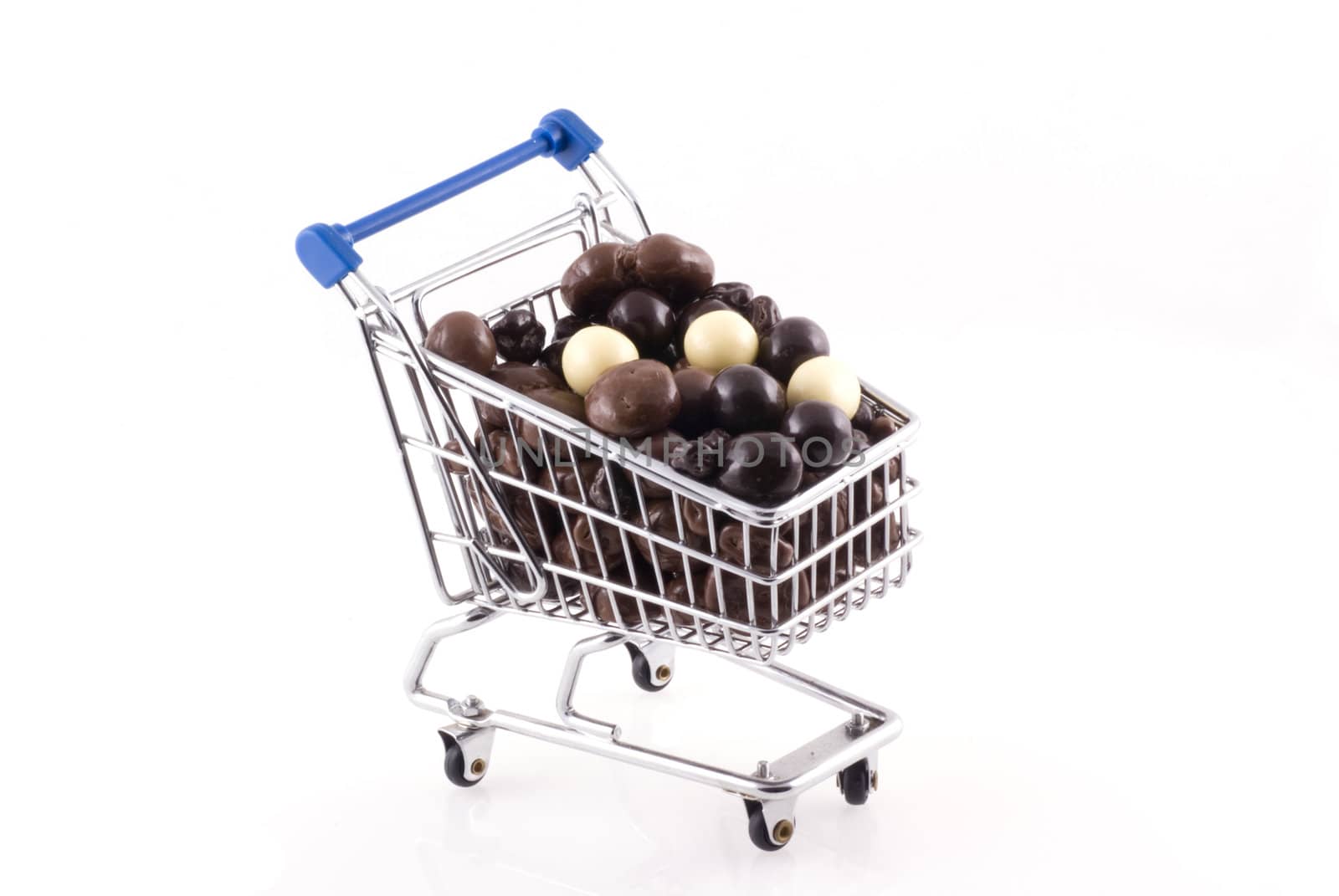 Shopping cart full of chocolate, isolated on white.