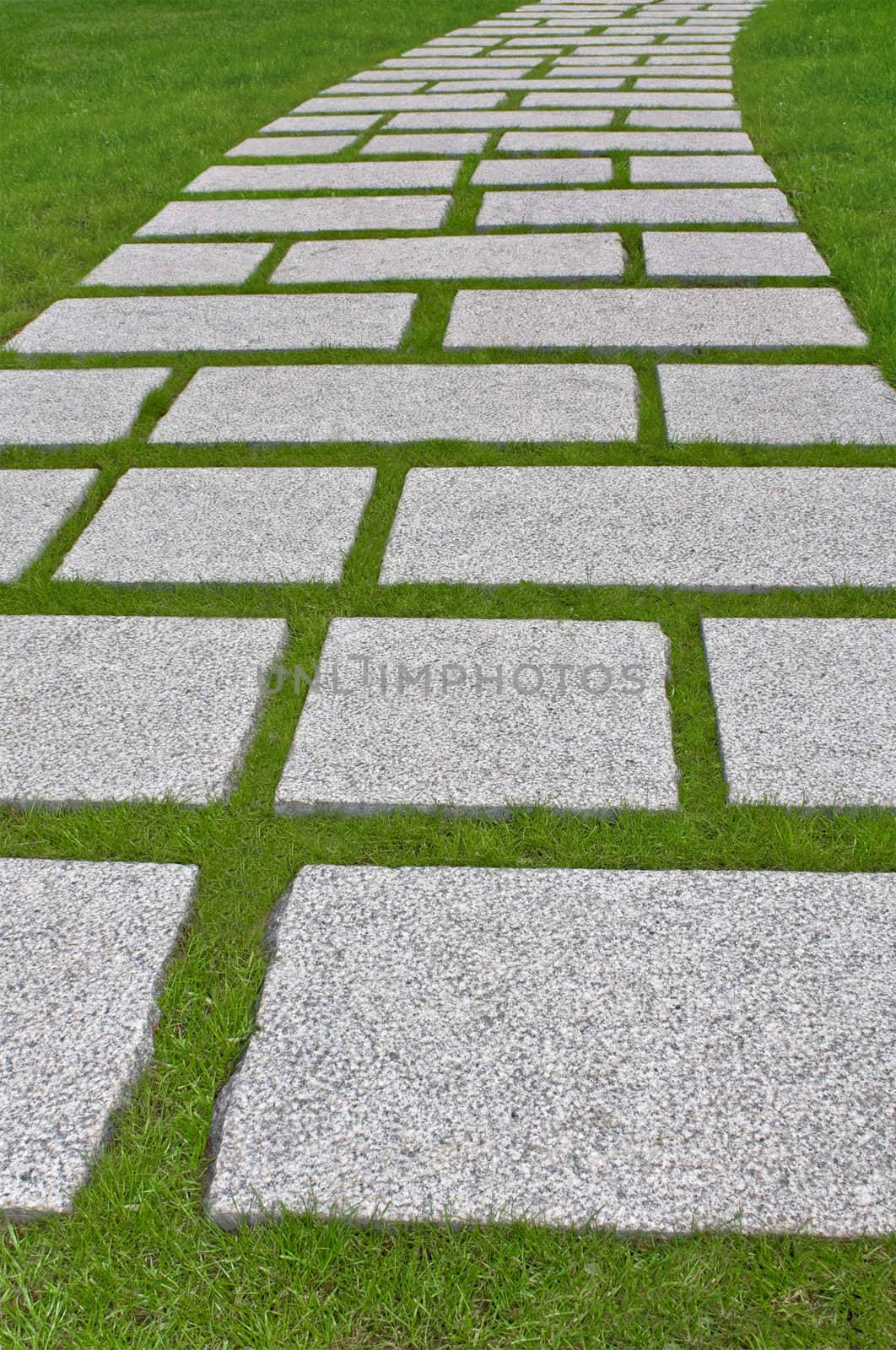 Granite path laid out on a green grass