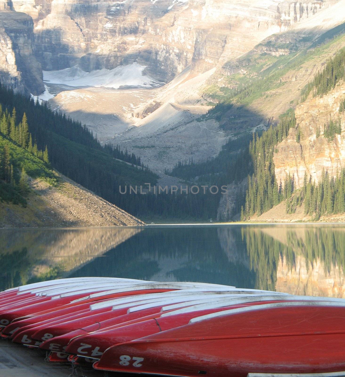 canoes by a lake and mountains