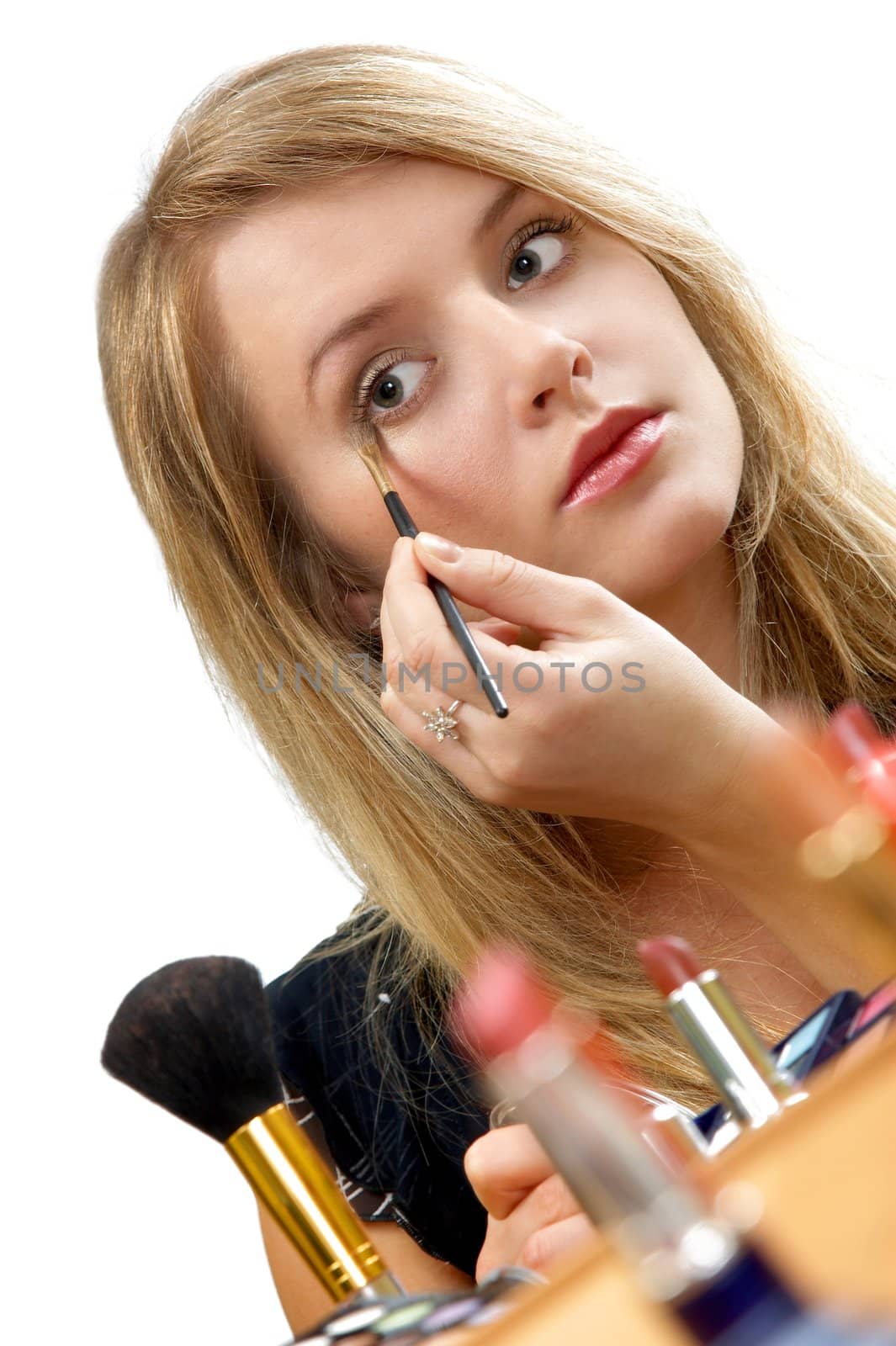 young beautiful woman is making up for itself in front of a mirror