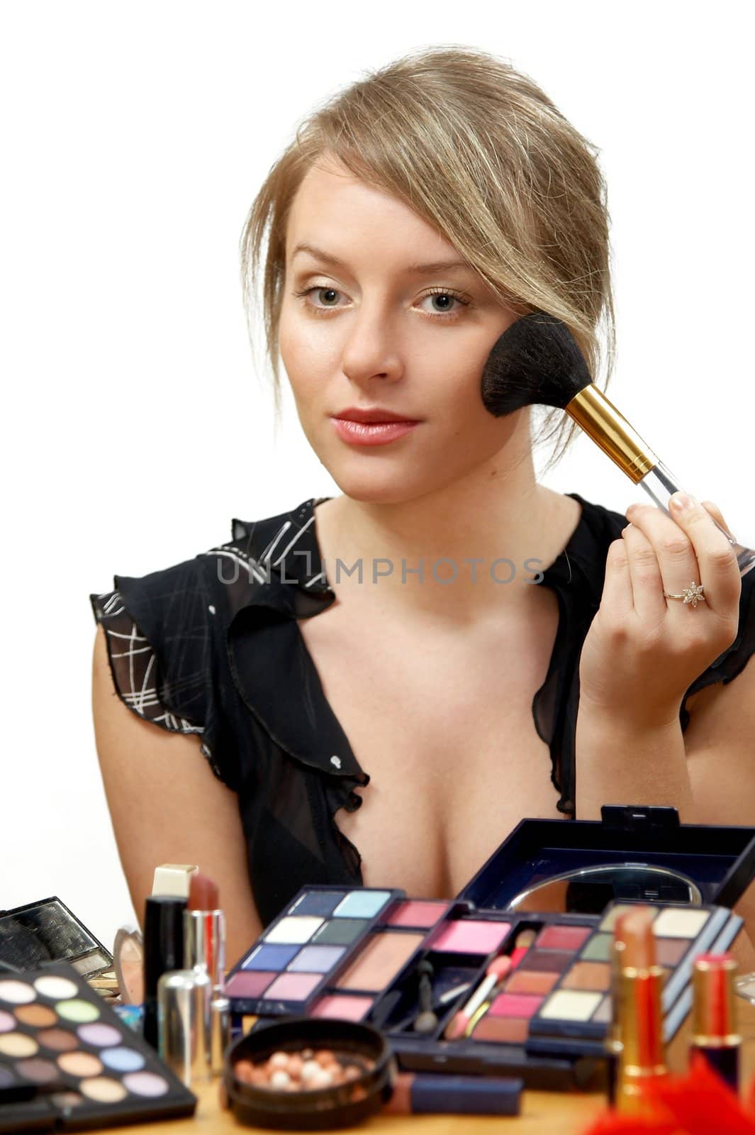 young beautiful woman is making up for itself in front of a mirror