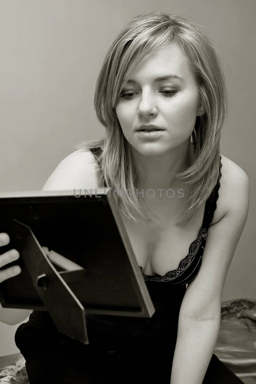  pretty woman is looking at photograph, black and white photo