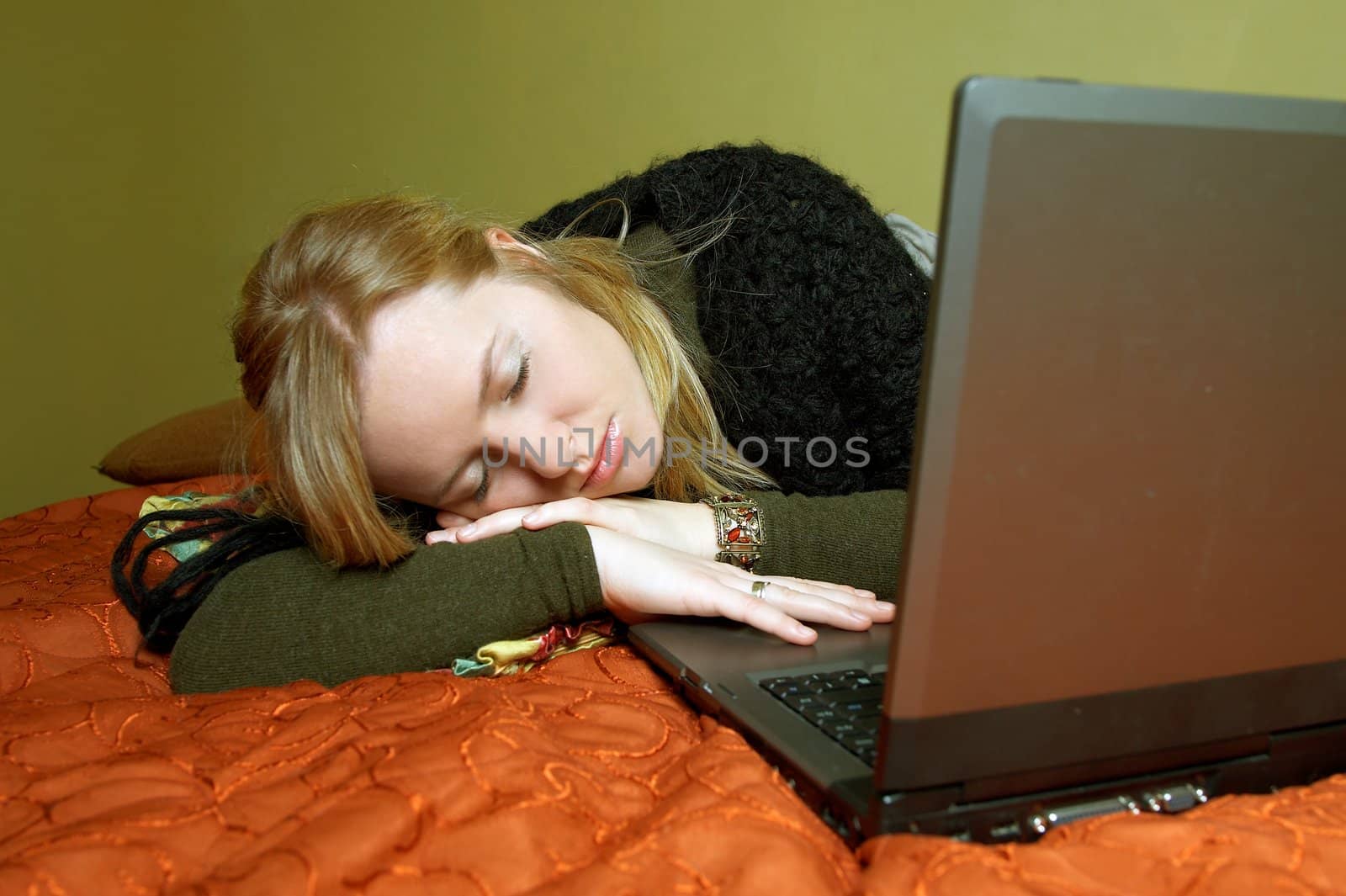 Tired woman on bed with computer