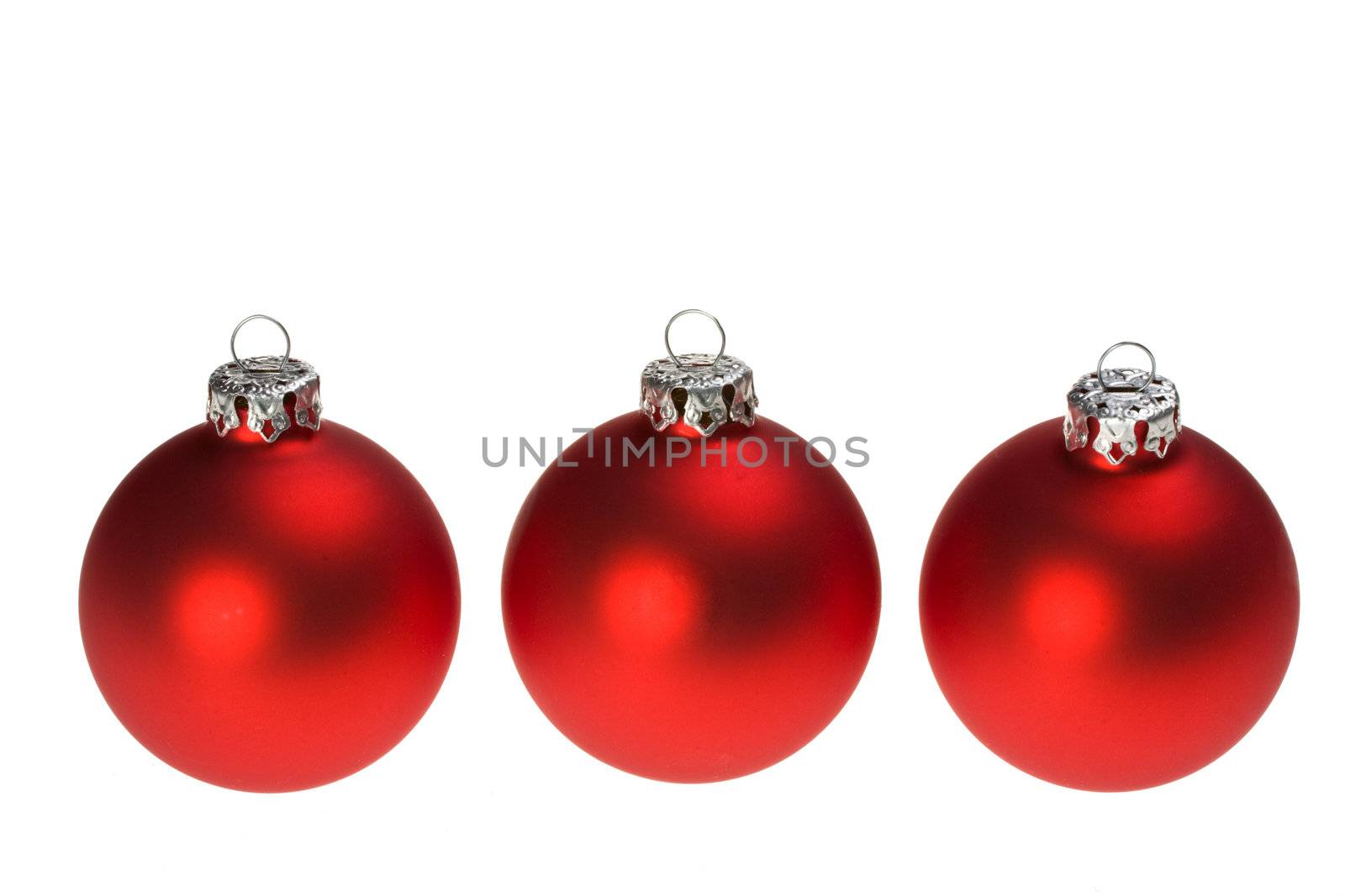 three red christmas baubles isolated on white background by bernjuer