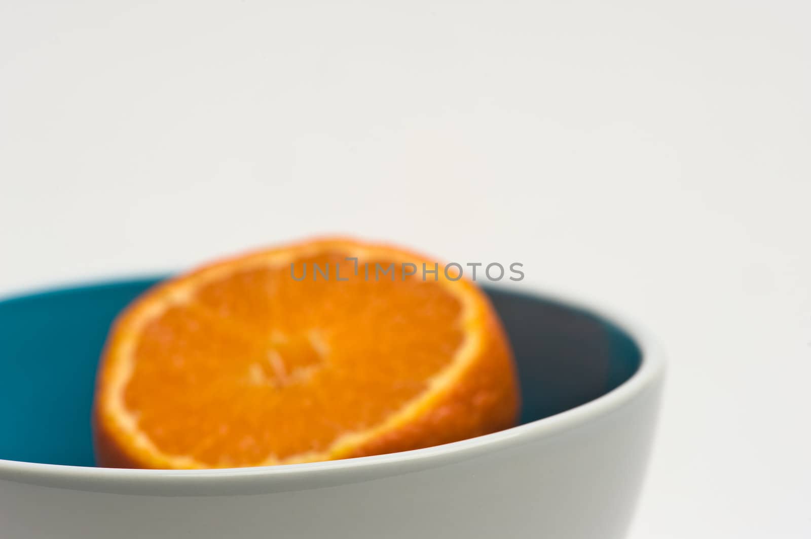 tangerine in blue and white bowl on white background